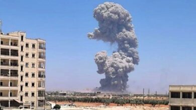 صورة لموقع الانفجار في بلدة كفرتخاريم بريف إدلب، تُظهر آثار الدمار وانتشار فرق الدفاع المدني في المنطقة